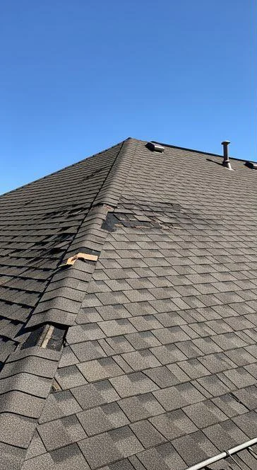 Worn shingle roof with damaged areas before the repair